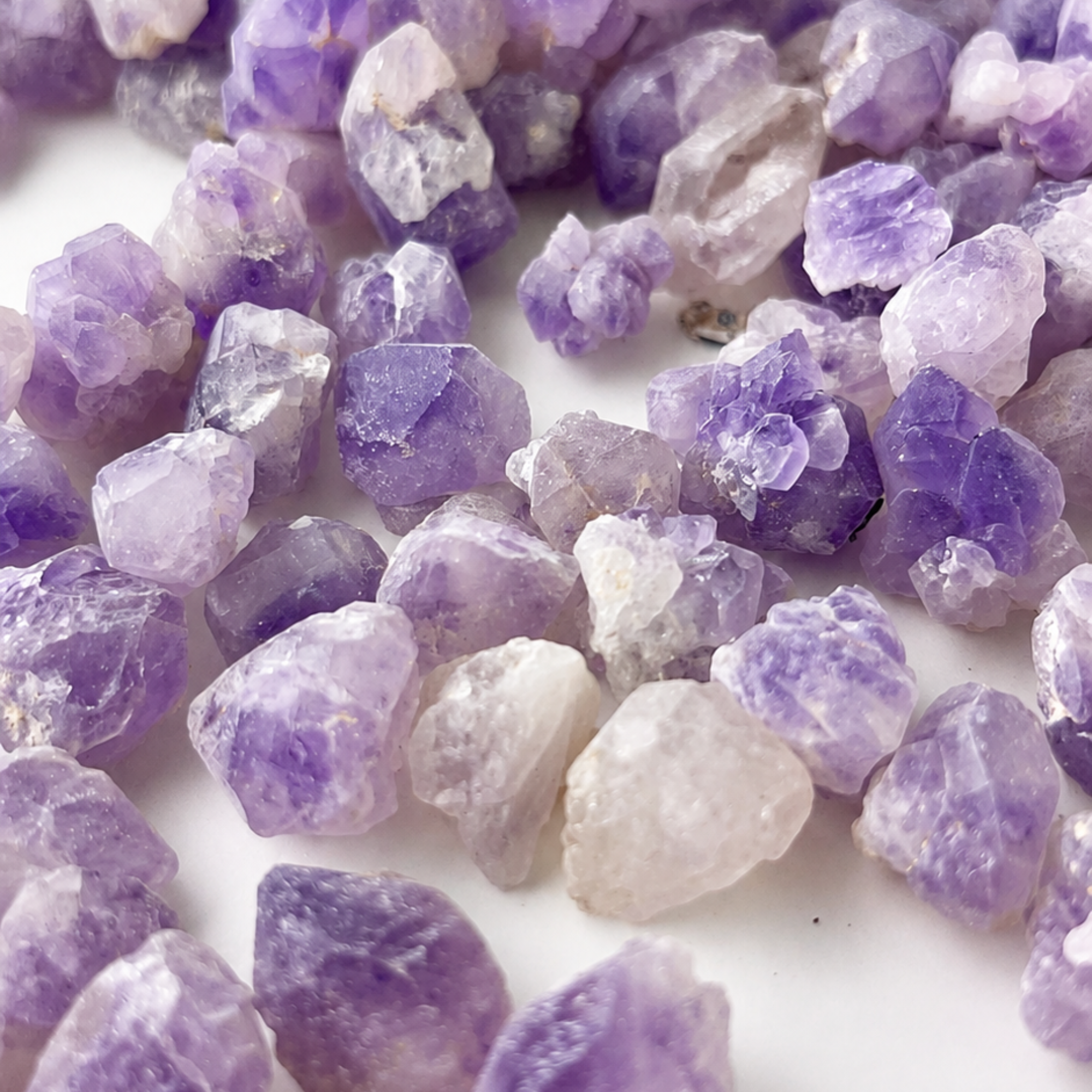 Close-up of mini raw amethyst crystal points from Brazil with natural purple and white variations