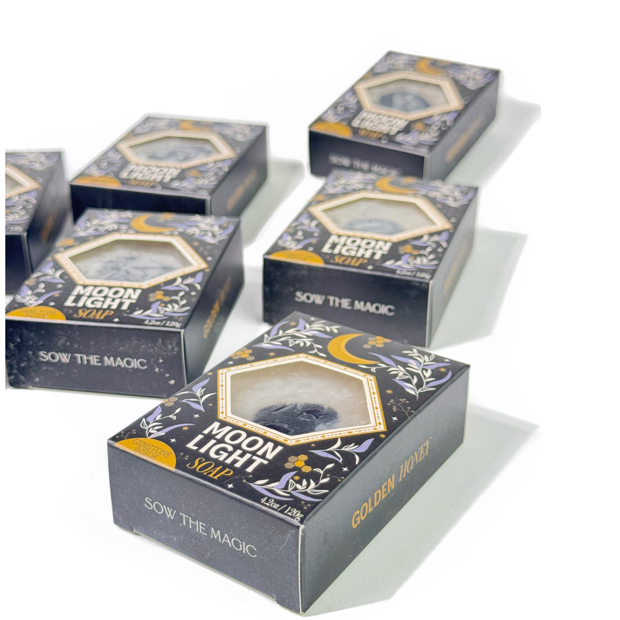 Flat lay of Moonlight Gemstone Soaps arranged neatly on white surface showing Sow the Magic branding and golden accents.