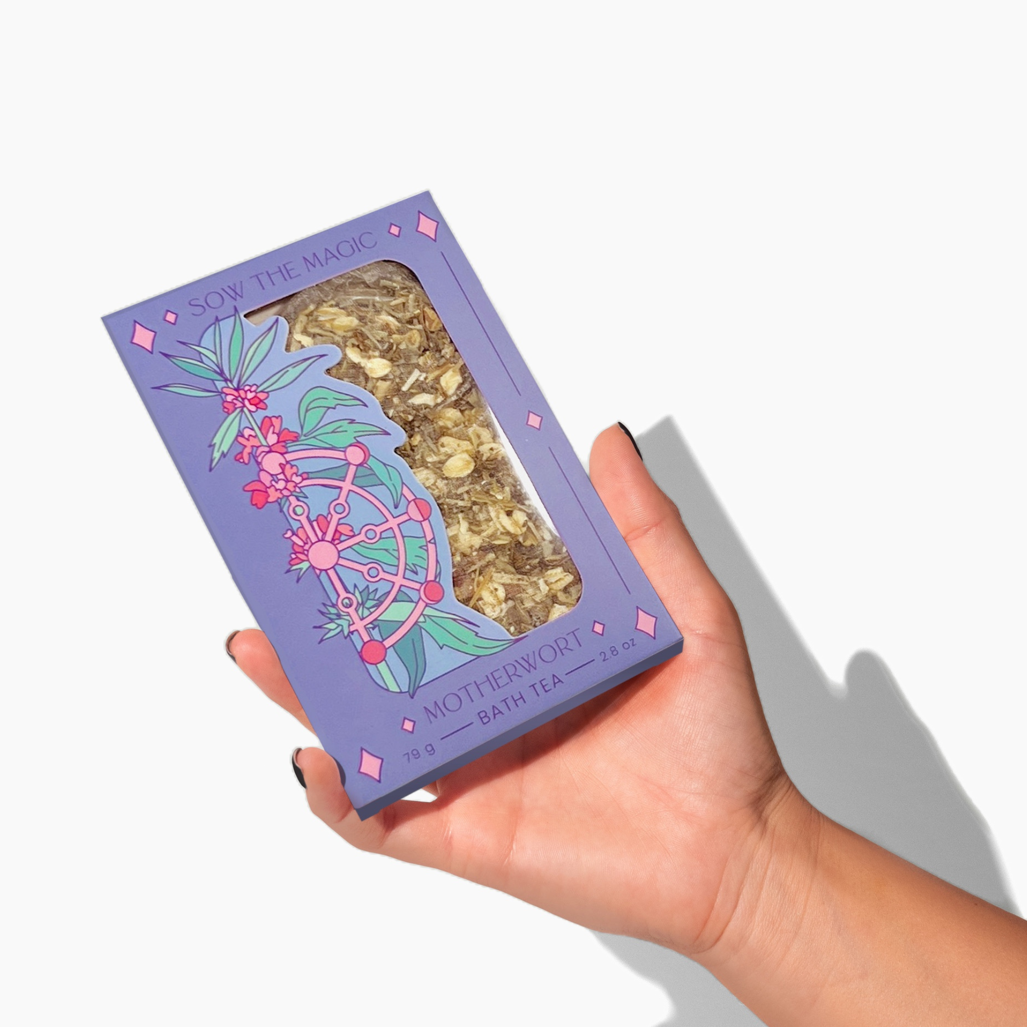 Hand holding Motherwort Tarot Botanical Bath Tea Box by Sow the Magic showing purple packaging and herbal blend inside.