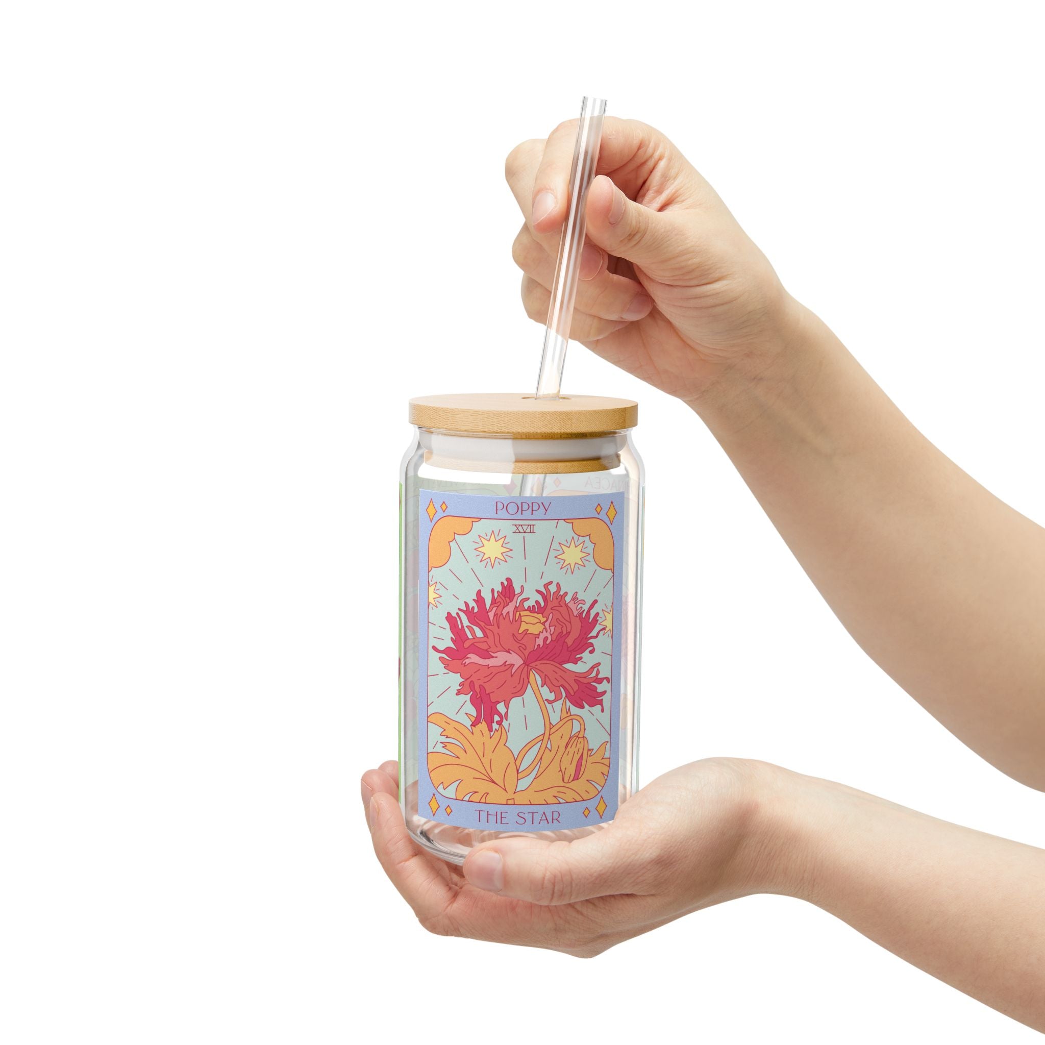 Hand holding Sow the Magic Poppy tarot glass tumbler with botanical seed packet illustration