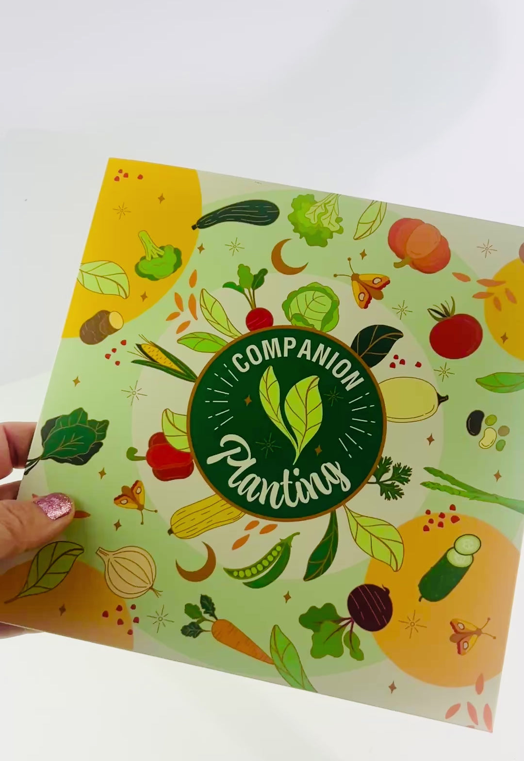 Companion planting wheel and booklet showing illustrated vegetables like tomatoes, carrots, cucumbers, and leafy greens for gardening tips
