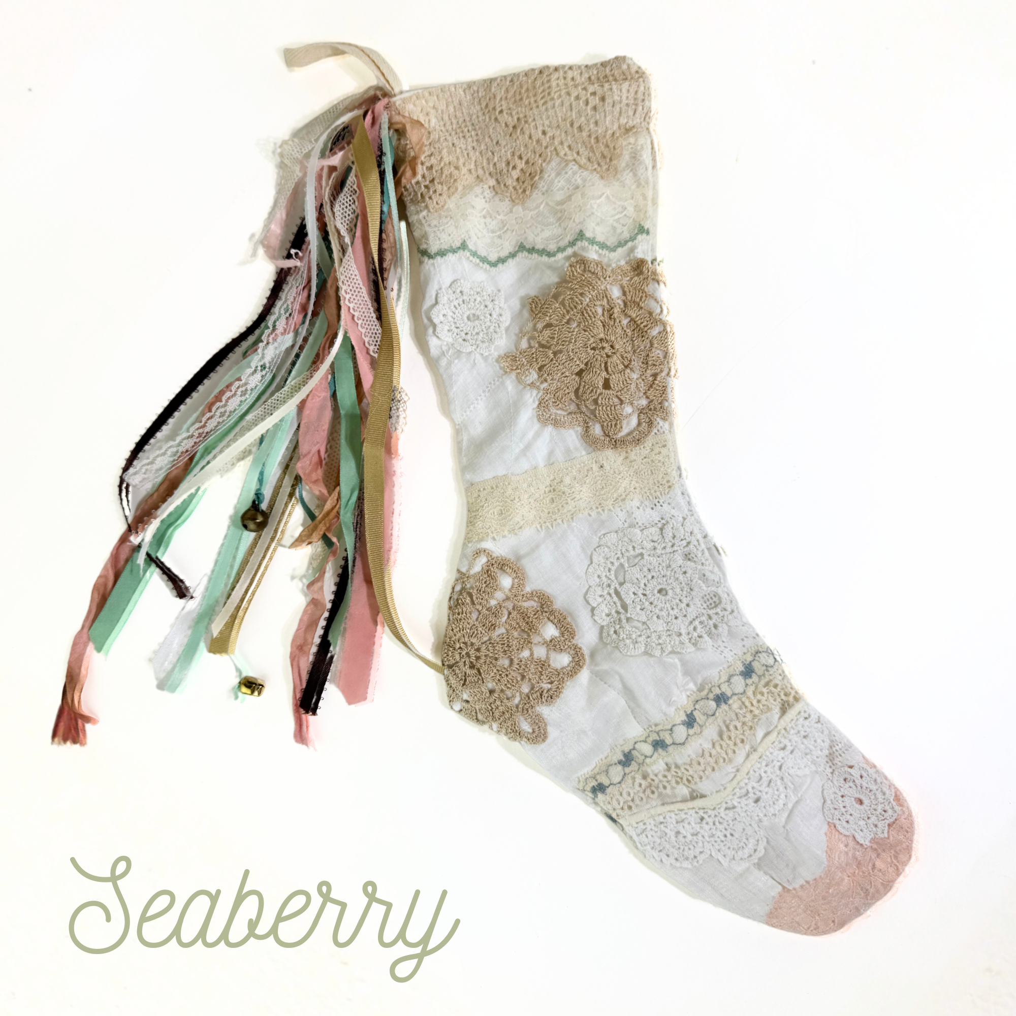 Handmade lace Christmas stocking with mint, blush, and beige ribbon tassels and vintage crochet lace