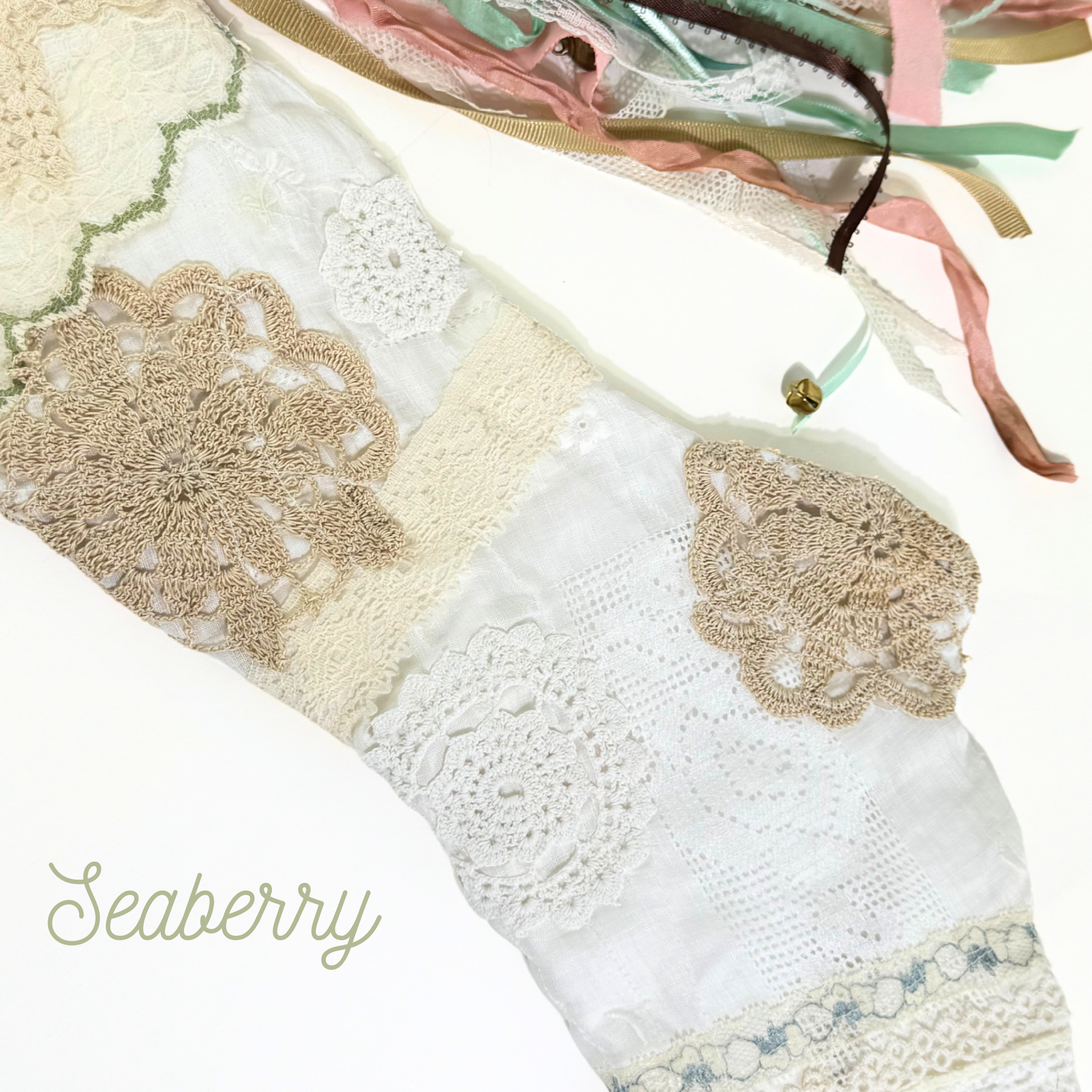 Top of handmade lace Christmas stocking with crochet trim, mint lace accent, and multicolor ribbon tassels