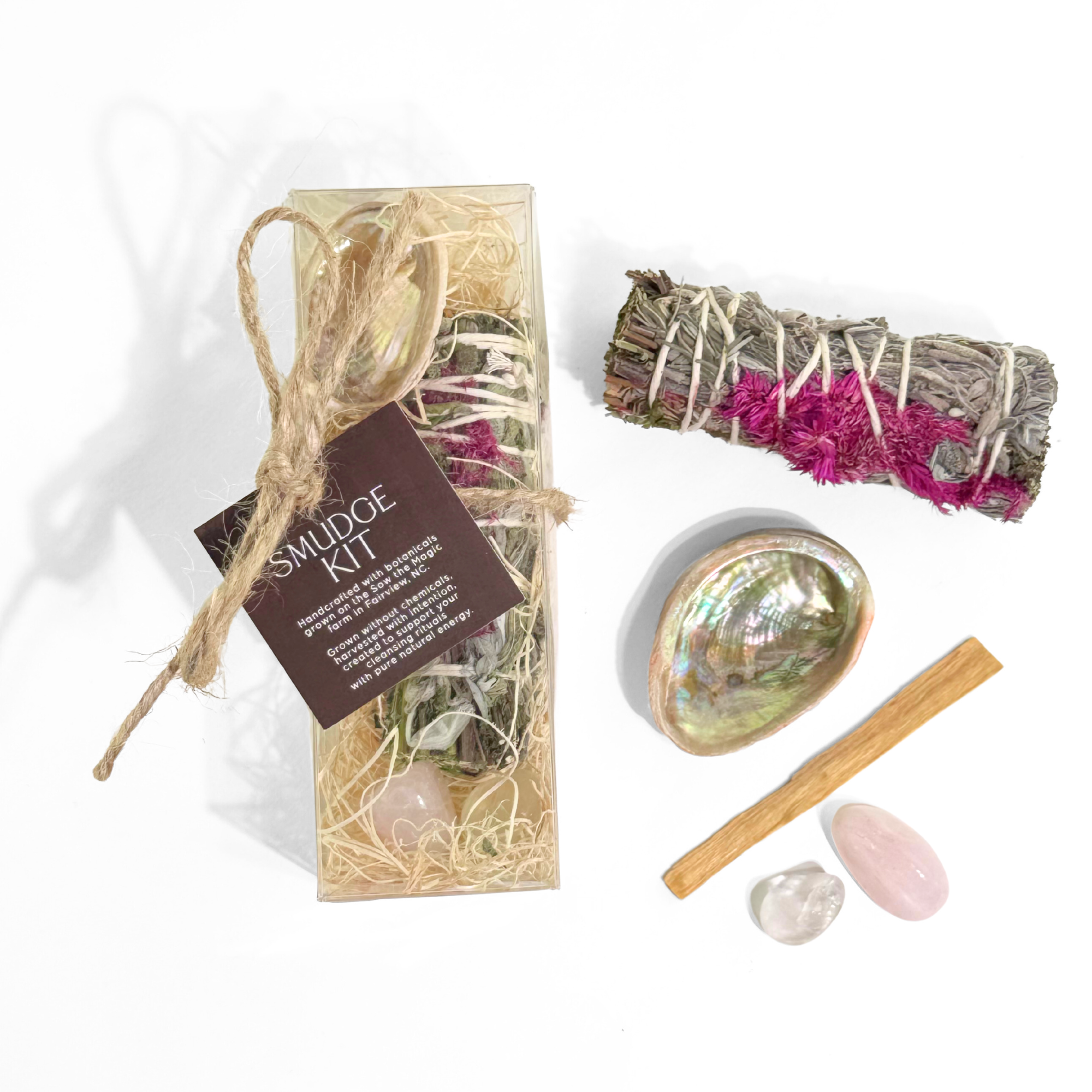 Unboxed smudge kit displayed with botanical smudge stick palo santo abalone shell and two tumbled gemstones.