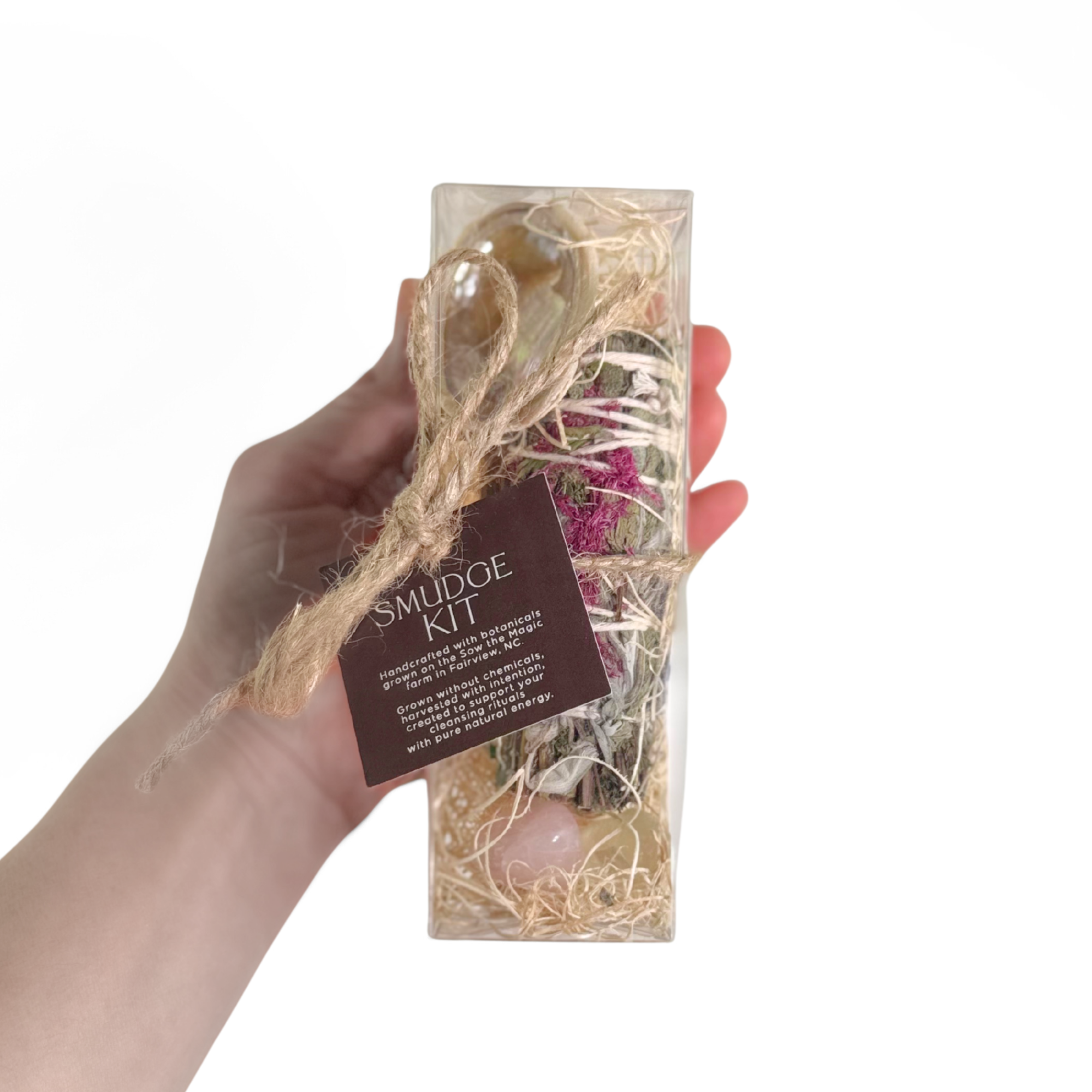 Smudge kit held in hand showing smudge stick gemstones palo santo and abalone shell inside gift box.