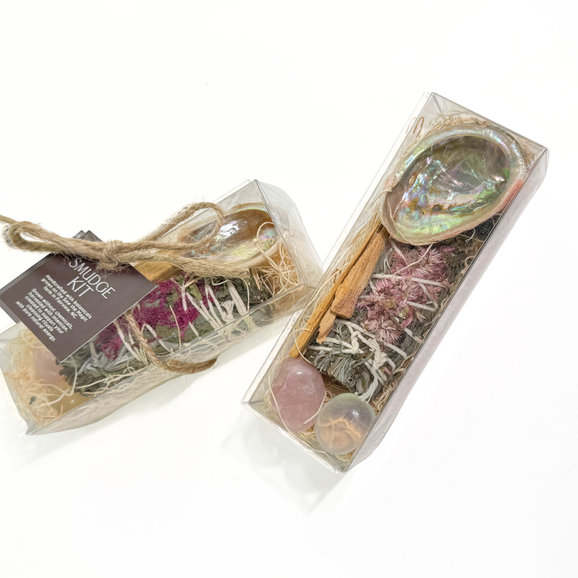 Smudge kit shown with abalone shell smudge stick palo santo and gemstones arranged in clear ritual gift box.