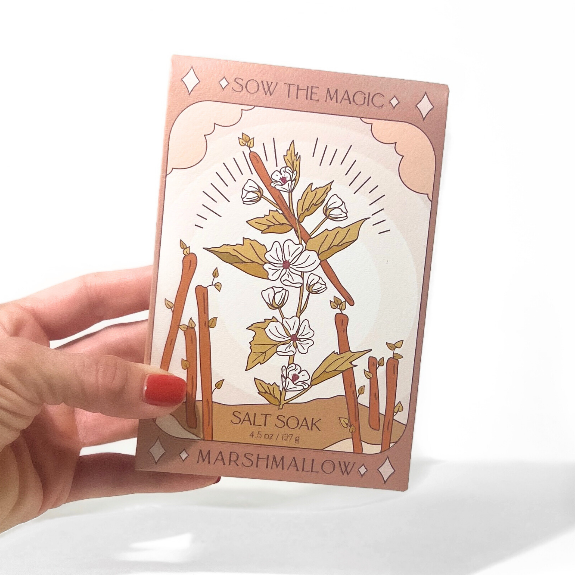 Marshmallow Salt Soak tarot box held in hand, showing floral design and warm neutral tones