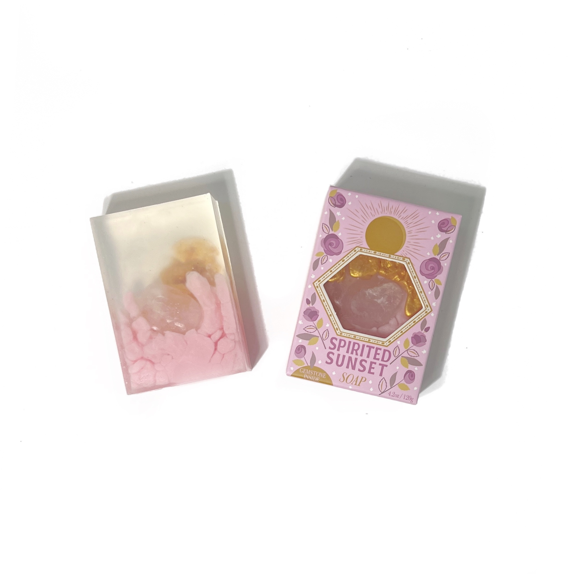 Spirited Sunset Gemstone Soap unboxed beside packaging showing pink and gold layers with embedded rose quartz.