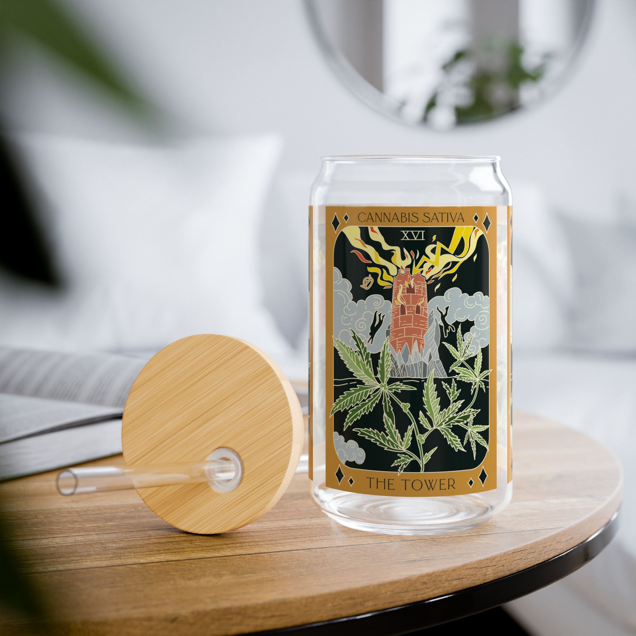 The Tower Cannabis Sativa tarot glass tumbler styled on a table with removable bamboo lid and straw