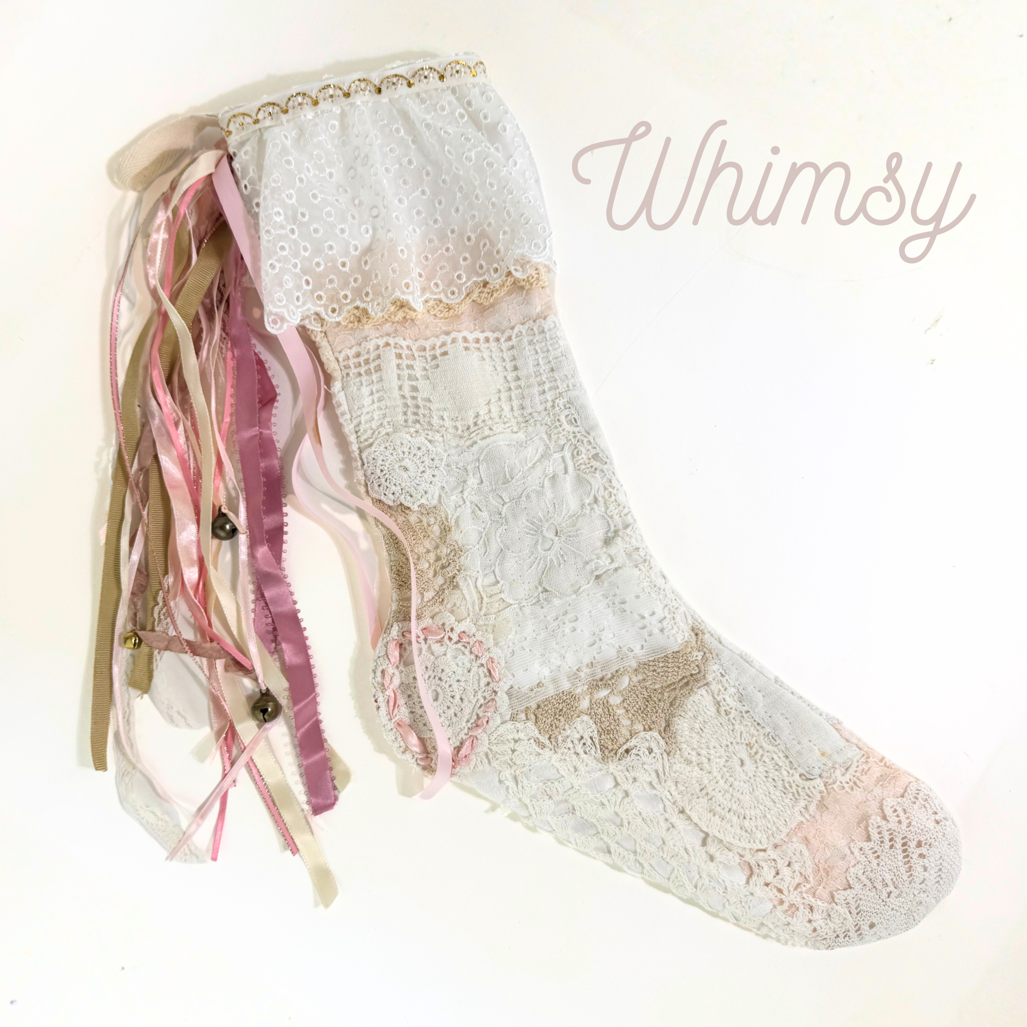 Handmade lace Christmas stocking with pink and tan ribbon tassels and vintage patchwork lace design