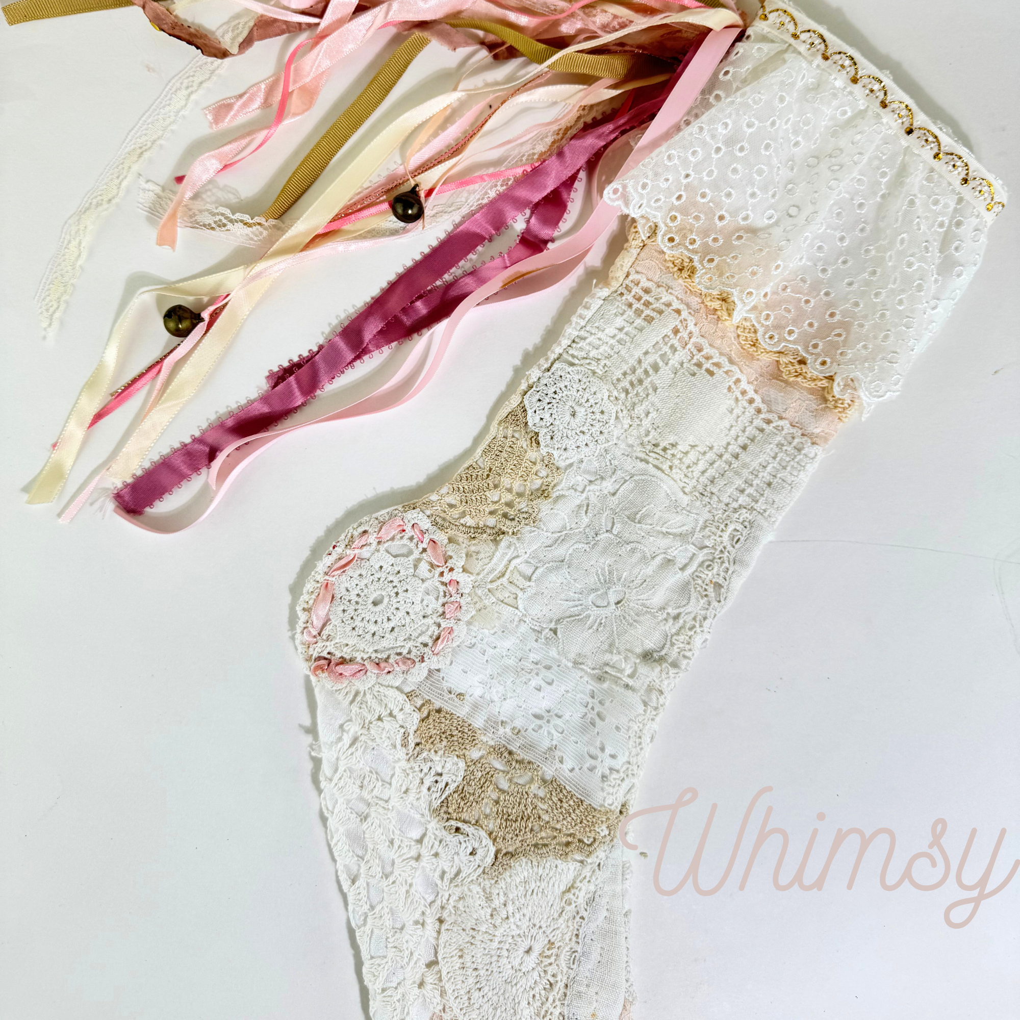 Close-up of Whimsy lace Christmas stocking showing pastel ribbons, crochet lace, and embroidered detail