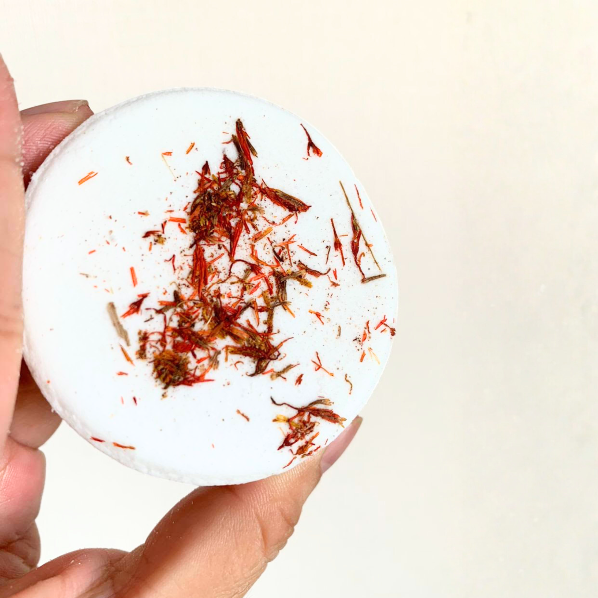 Single wild rose shower steamer topped with rose petals on white background