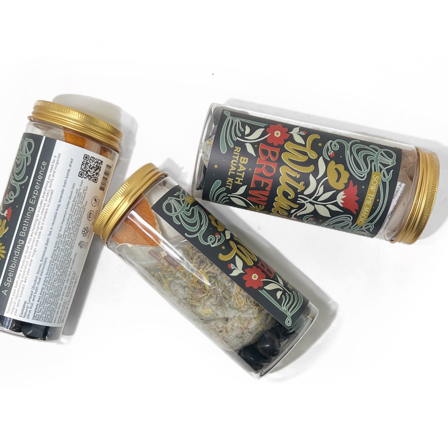 Overhead view of Witch’s Brew Bath Ritual Kit jars with visible herbal bath mix, obsidian stones, and dried orange slice.
