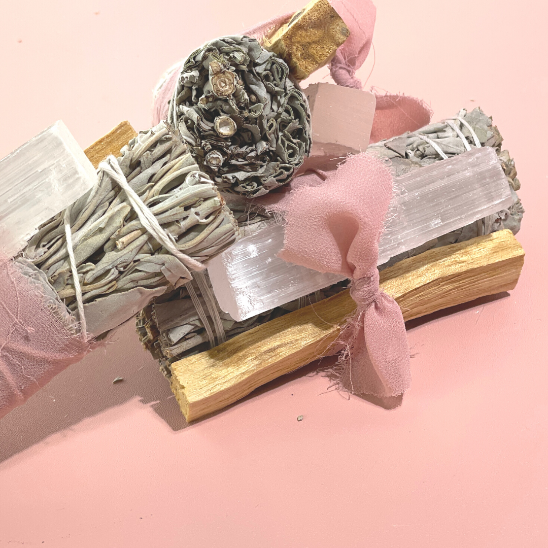 handcrafted White Sage Protection Ritual Bundles featuring White Sage, Palo Santo, a genuine Selenite cleansing wand and soft blush ribbon. Handmade spiritual gift sets by Sow the Magic®.