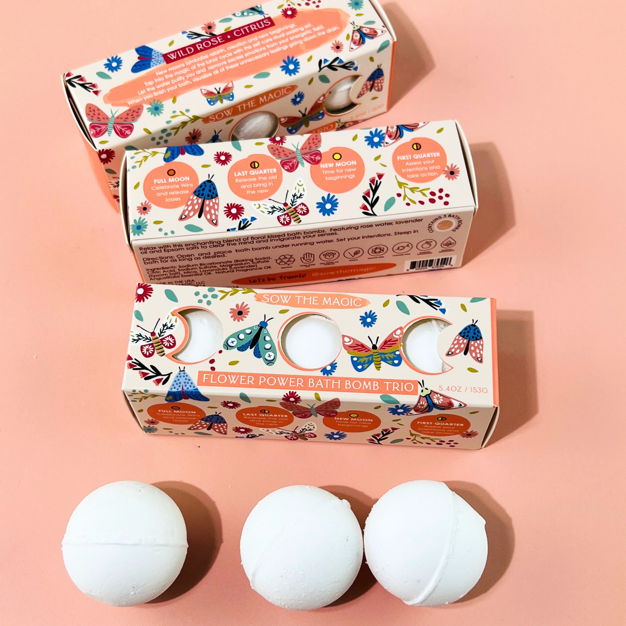 Sow the Magic Flower Power Bath Bomb Trio with floral packaging and bath bombs arranged on pink surface