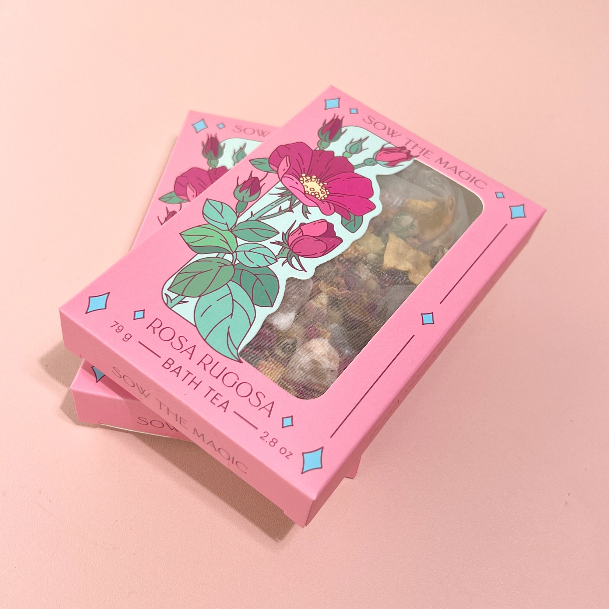 Rosa Rugosa Tarot Botanical Bath Tea Boxes by Sow the Magic displayed on pink background with rose illustration and window packaging.